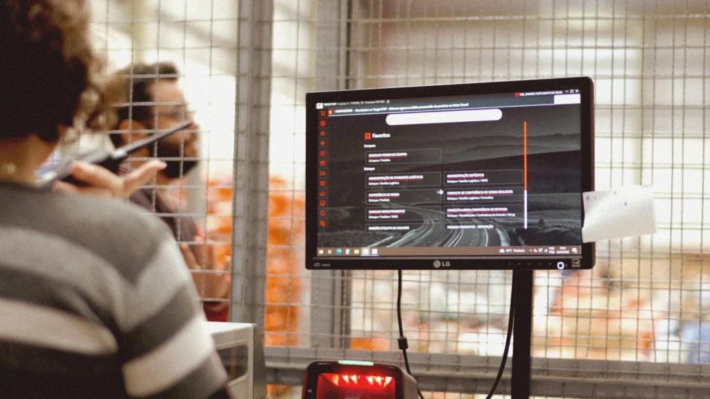 Profissionais utilizando o sistema da Target em ambiente corporativo, representando a integração total da gestão e atualização contínua das soluções para distribuidoras.