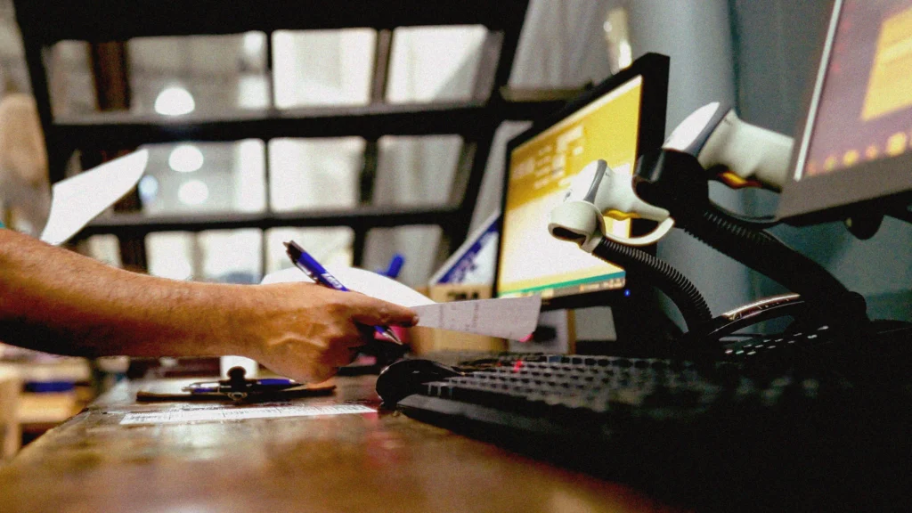 Profissionais organizando remessas e conferindo caixas em centro de distribuição, representando a gestão de transporte e emissão de CT-e com o sistema da Target.